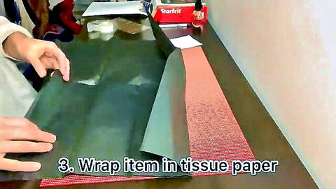 Hands wrapping panty order in tissue paper from MV store
