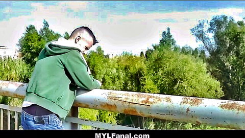 Guy in green hoodie leans over railing with jeans sagging exposing black underwear ass crack outdoors