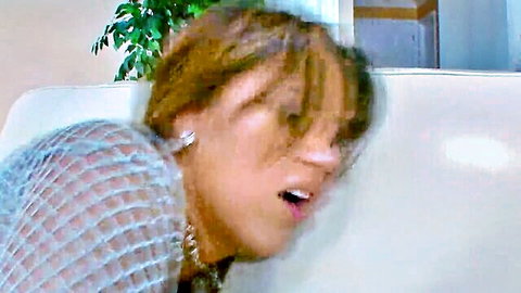 Brunette with big tits in sheer mesh top moans with open mouth on couch