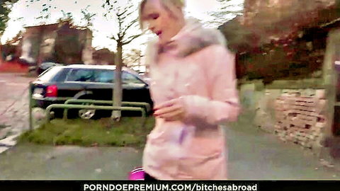 Blonde babe in open pink fur jacket teasing outdoors on urban street