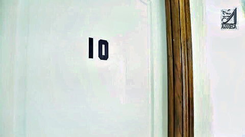 White hotel room door numbered 10 with wooden trim