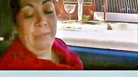 Latina woman in car with eyes closed in ecstasy, pink top