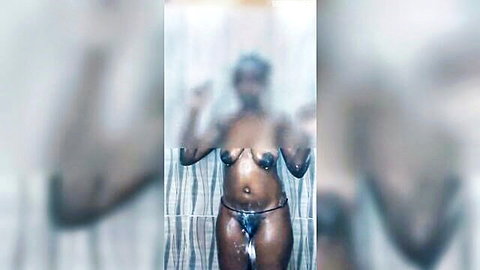 Pregnant ebony woman in steamy shower wearing black bikini