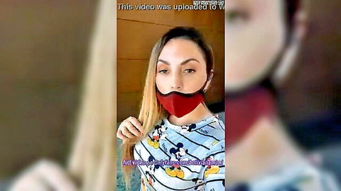 Sexy Latina in low-cut Mickey Mouse top and red mask smiles seductively with cleavage tease
