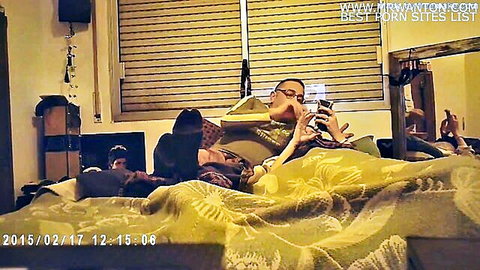 Girl deepthroating DILF's cock on yellow bed while he holds phone
