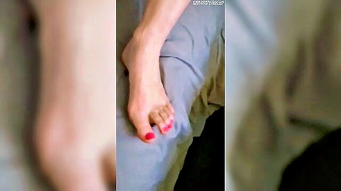 Close-up of bare female foot with red toenails, nude solo tease