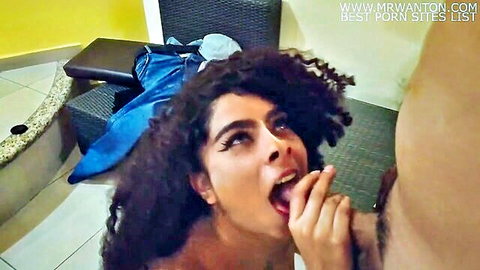 Curly-haired Latina brunette sticks tongue out licking thick cock in sloppy blowjob closeup