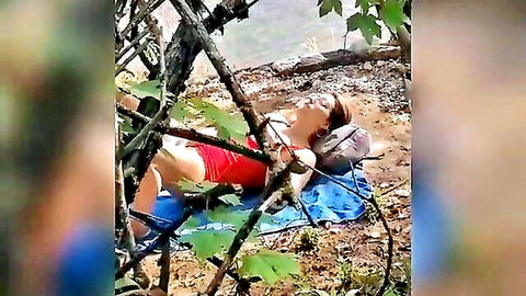Blonde wife lies topless exposing huge tits outdoors on blue tarp in red shorts