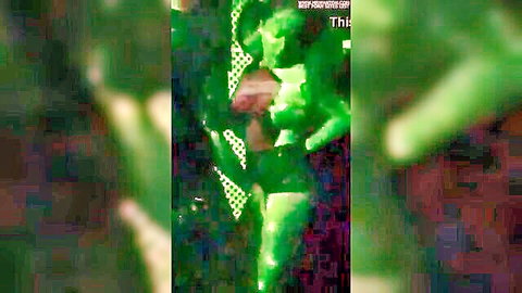Blurry green-tinted KTV scene with seductive woman in revealing outfit