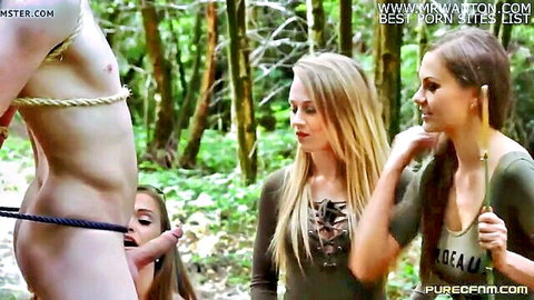 Three sexy babes in green tops suck off tied guy outdoors in forest