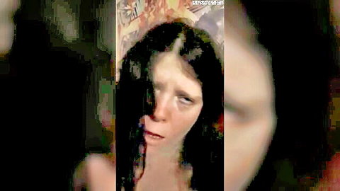 Blurry close-up of pale woman with long black hair, wide eyes and open mouth in intense expression