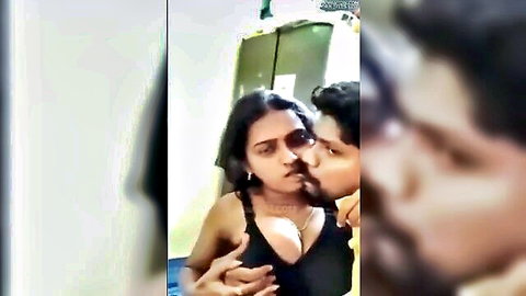 Passionate Indian couple kissing intimately, woman's cleavage in black top