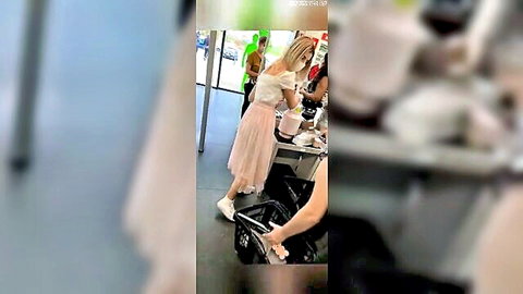Blonde woman bending over in pink skirt, upskirt view in store, voyeur style