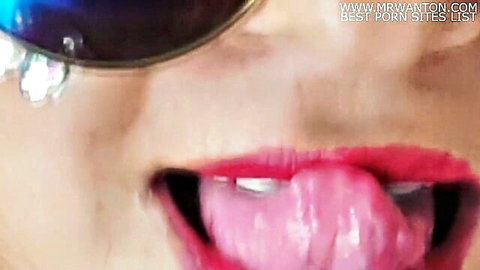 Seductive woman with red lipstick and blue sunglasses sticks out her wet pink tongue teasing for cock.