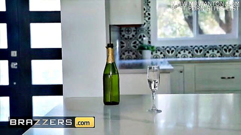 Green champagne bottle and flute glass on white kitchen counter in Brazzers porn scene