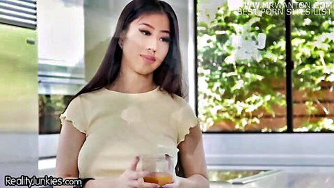 Busty Asian Jade Kush in tight top, holding drink, seductive smile