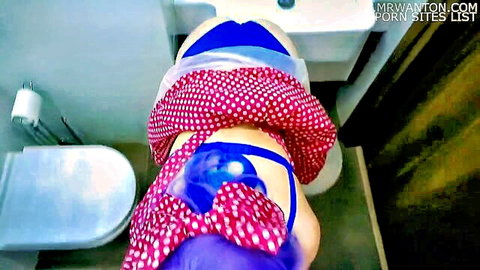 Purple-haired cosplay teen in pink polka-dot skirt and blue panties on toilet