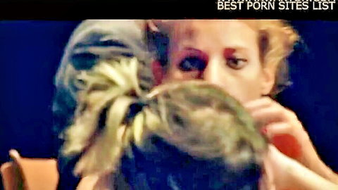 Two blonde women passionately French kissing in intense close-up