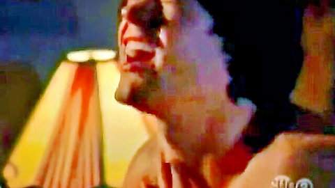 Intense bearded man with open mouth and wide eyes under dramatic lamp light in sensual erotic scene