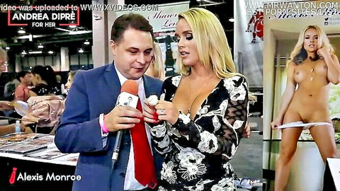 Blonde bombshell in low-cut dress flashes deep cleavage at AVN booth with nude poster showing spread pussy