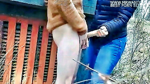 Bottomless woman bent over outdoors with bare ass and pussy exposed grabbed by two clothed guys