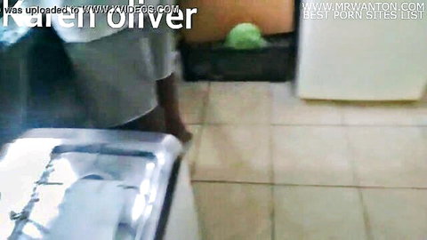 Amateur brunette Karen Oliver bends over kitchen sink in tight gray skirt teasing ass