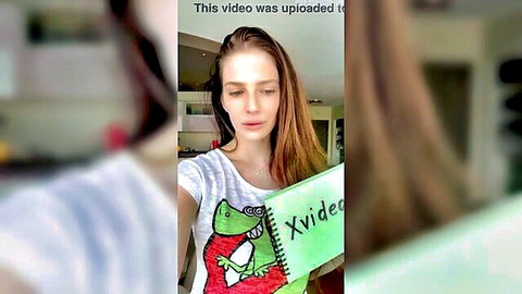 Amateur brunette woman in casual white t-shirt holding XVideos notebook selfie