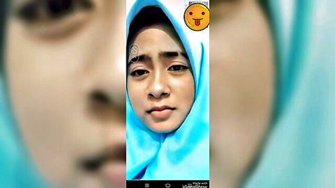 Indonesian girl in blue hijab smiling playfully for adult video