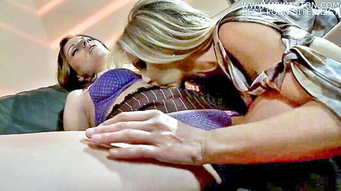 Blonde lesbian kissing and licking brunette's tits in purple lingerie on bed