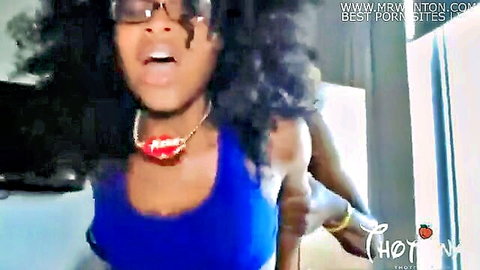 Ebony babe with glasses and red lips necklace opens mouth wide in tight blue tank top