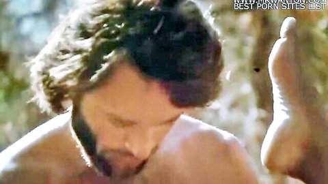 Shirtless bearded man gazes at raised woman's foot in outdoor erotic scene from Vacances Sexuelles
