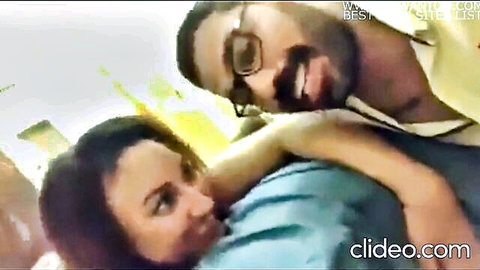 Egyptian woman in blue top hugged intimately by bearded man with glasses
