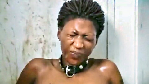 Ebony woman with braids in BDSM collar, nude sucking face expression