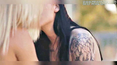 Hot blonde passionately kissing tattooed brunette's neck in steamy lesbian encounter