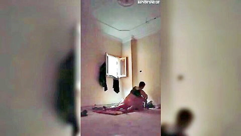 Blurry Arab MILF in red outfit sitting spread-legged on bedroom floor with man nearby