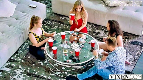 Sexy blondes and brunette babe in revealing outfits play poker with handsome stud around glass table