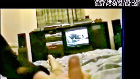 Amateur guy strokes thick hard cock near wife's sexy foot on bed watching porn TV
