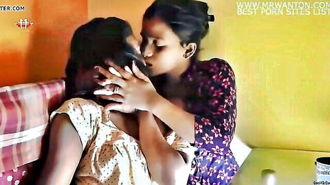 Two busty Indian lesbians passionately French kissing while groping faces on bed