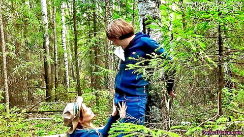 Brunette babe in hat kneels in forest reaching for stranger's cock in outdoor public tease
