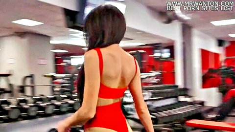 Brunette in revealing red swimsuit walking away in gym