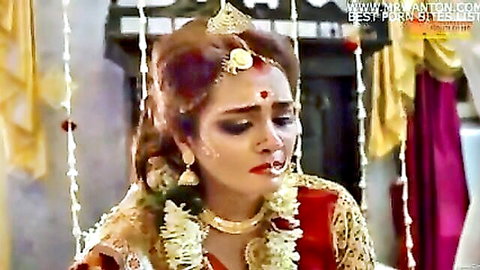 Teary-eyed young Indian bride in red wedding saree with sindoor and jewelry looking emotional