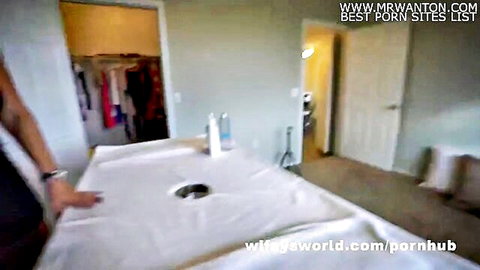 Empty homemade gloryhole booth setup with sheet-covered table hole in bedroom closet area