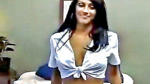 Busty South Asian woman smiling in tied white shirt exposing deep cleavage and huge tits