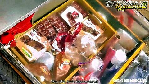 Supermarket shelf stocked with yellow boxes of carne del mercado meat products and beverages