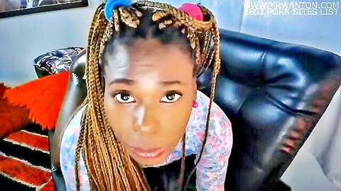 Ebony woman with colorful braids in floral top, teasing expression