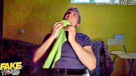 Fake Hostel man with gray hair holds green towel in casual scene with bisexual girls