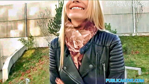 Smiling blonde in pink scarf and black leather jacket outdoors for public agent pickup