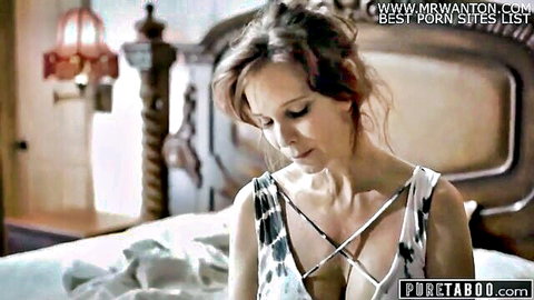 Brunette MILF in sexy crisscross top exposing cleavage, seductive pose