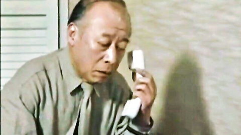 Older Asian man in shirt and tie talking on phone, cuckold theme teaser