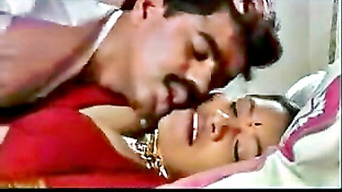 Indian man passionately kissing sexy South Asian woman's neck in bed
